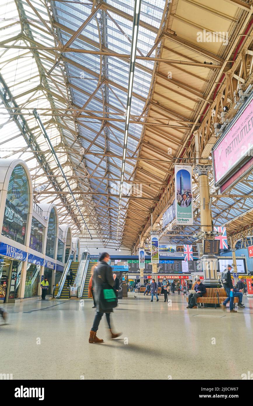 Passagers dans le hall de la gare de Victoria, Londres, Angleterre. Banque D'Images