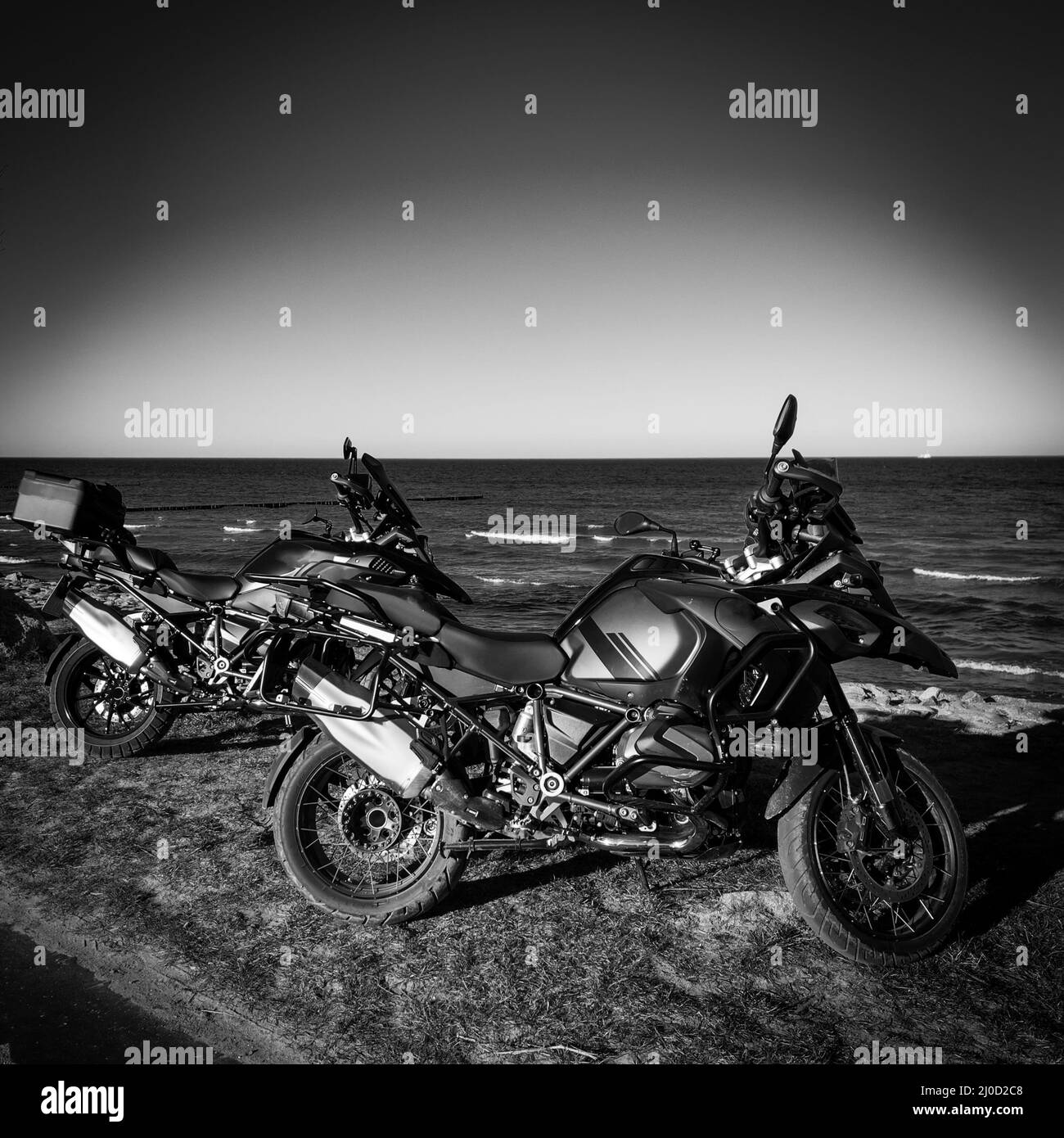 deux motos tout-terrain se tenant côte à côte près de la mer Banque D'Images