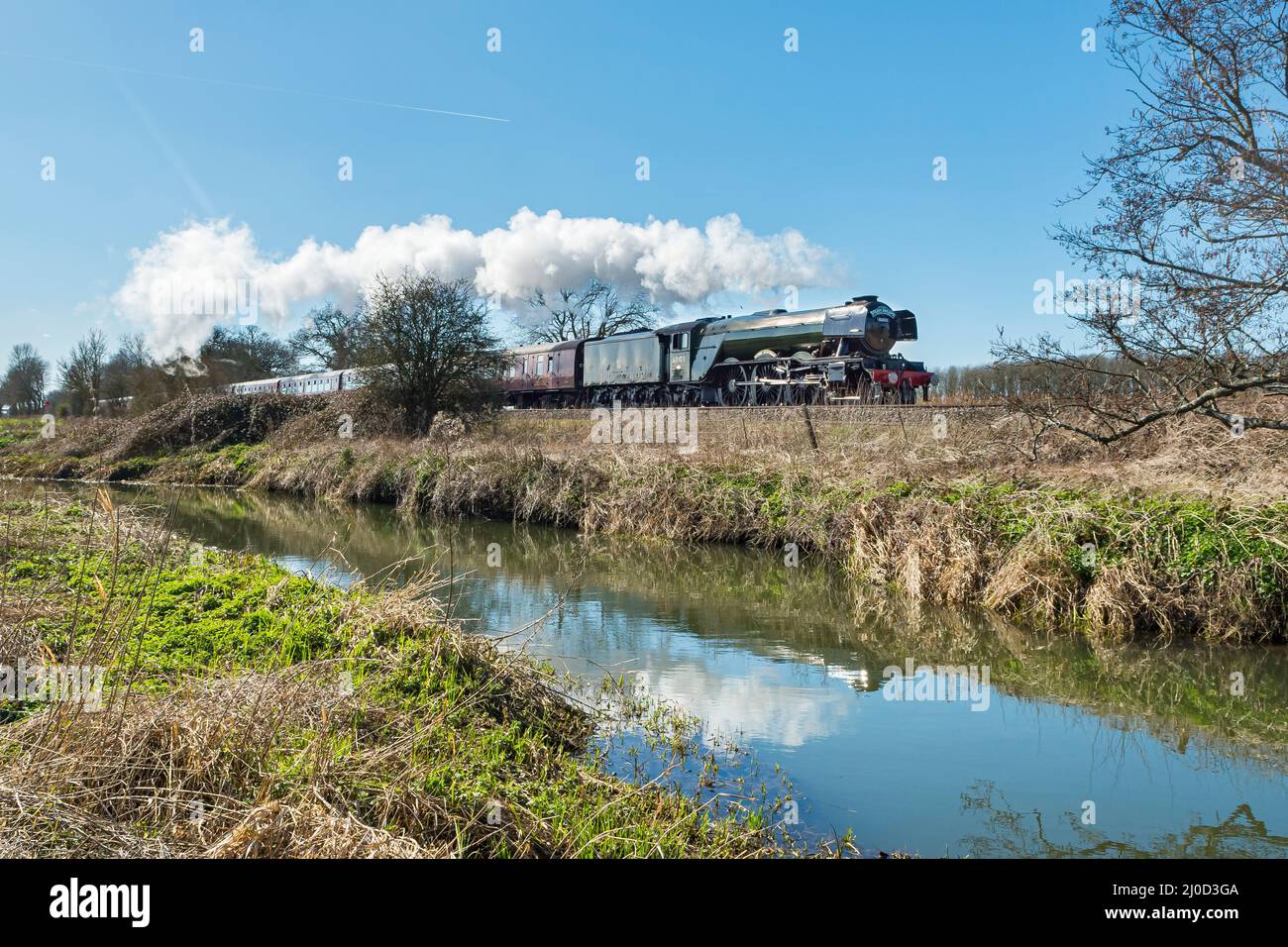 La locomotive à vapeur Flying Scotsman, propriété du Musée national des chemins de fer, traverse la campagne du Kent le long de la rivière Stour près de Wye Banque D'Images