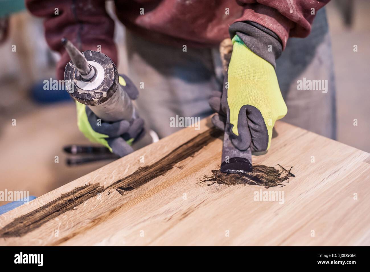 Homme faisant du travail du bois en charpenterie. Menuisier travaille sur la planche de bois en atelier Banque D'Images