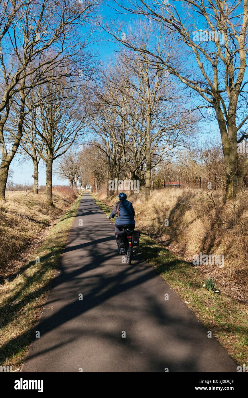 Femme sur un e-vélo sur la route à vélo Weser près de Petershagen. Banque D'Images