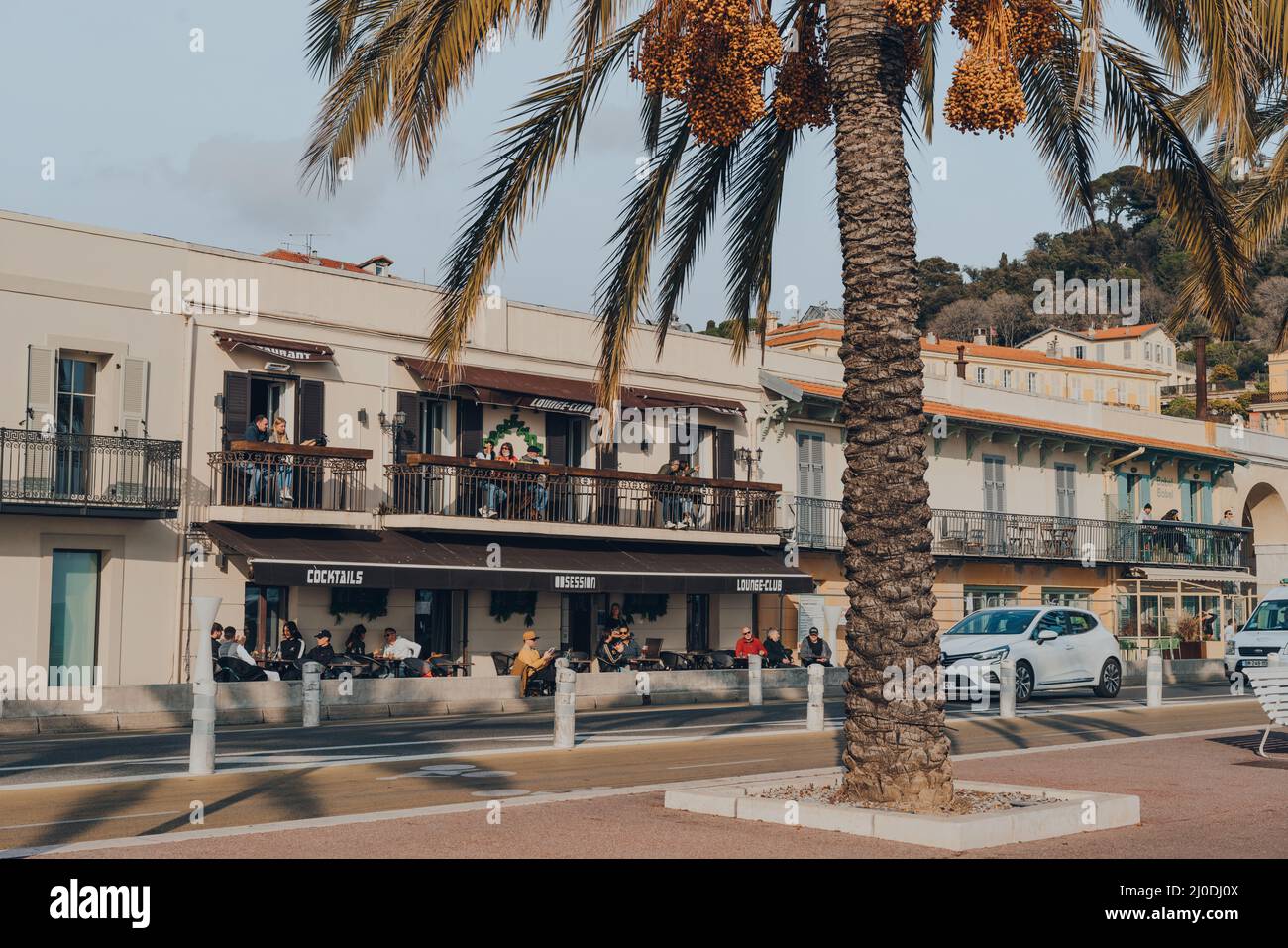 Nice, France - 10 mars 2022: Les gens se détendent aux tables extérieures du bar et salon obsession sur la Promenade des Anglais, une promenade de 7km de long al Banque D'Images