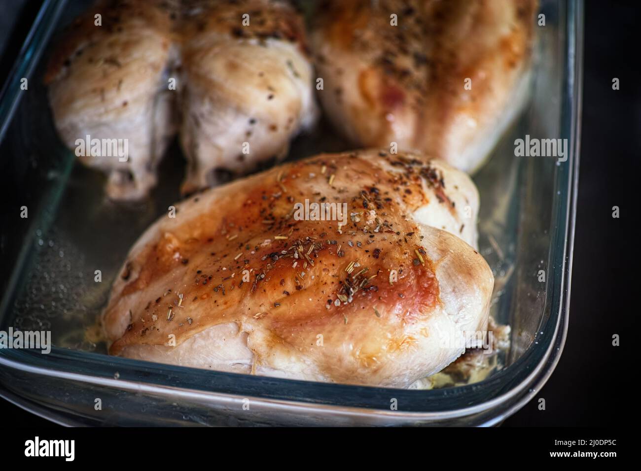 Poitrines de poulet rôties sur une plaque de cuisson en verre avec épices. Gros plan. Banque D'Images