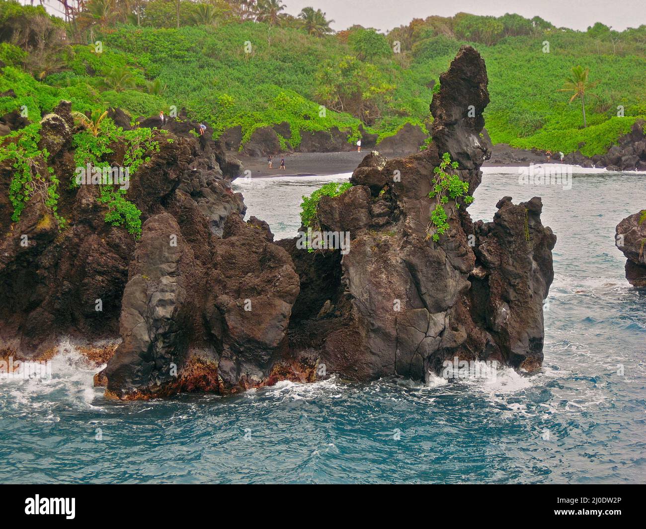 Les visiteurs explorent les falaises de Lava au parc national de Waianapanapa à Hana, Hawaï, sur l'île de Maui Banque D'Images