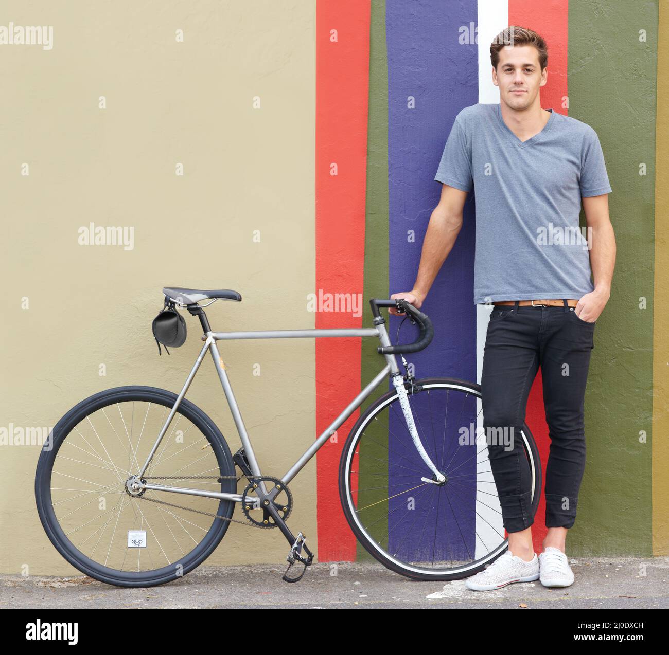 C'est parti ! Photo d'un jeune homme élégant debout à l'extérieur avec son vélo. Banque D'Images