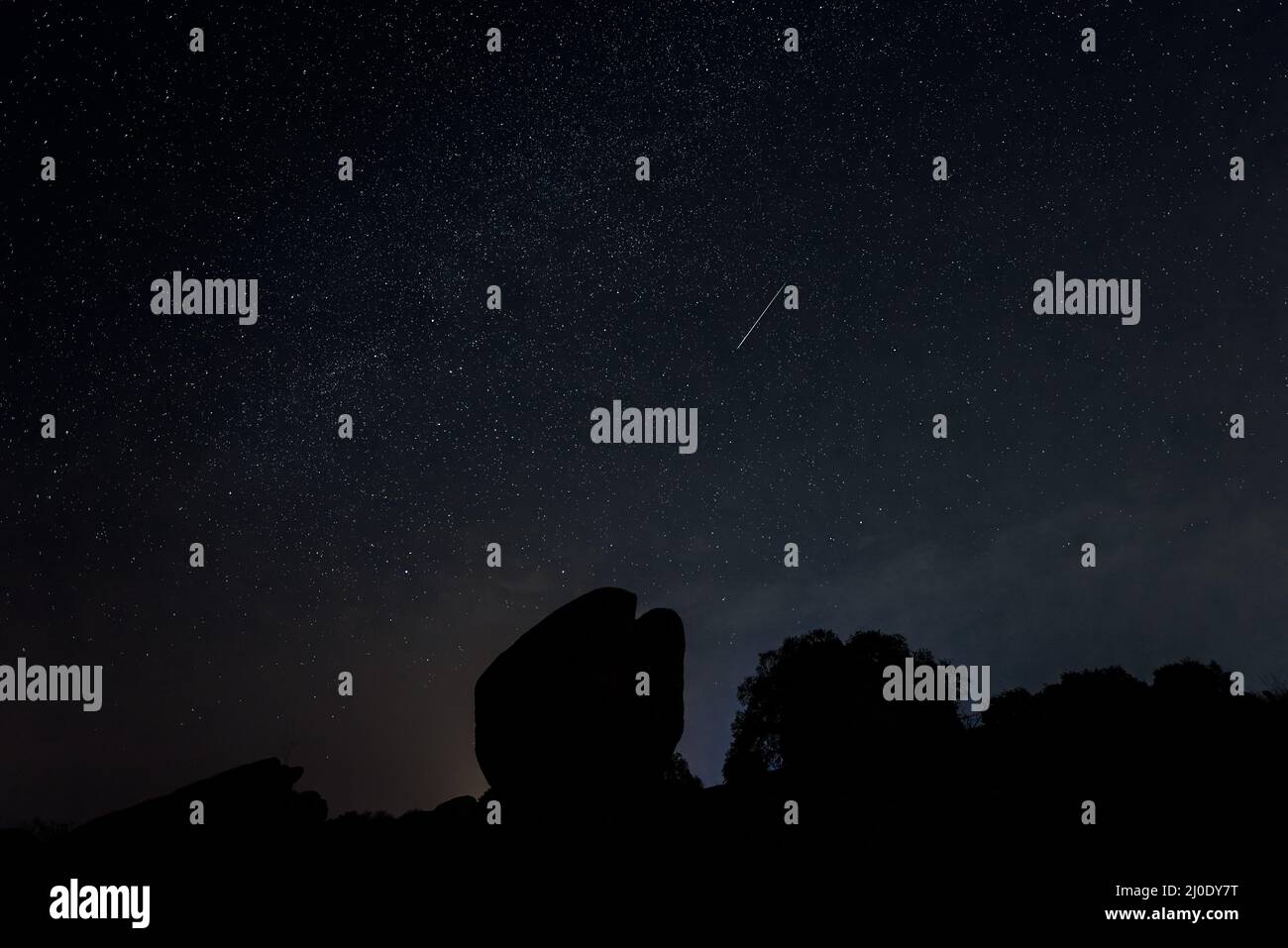Paysage de nuit avec météore de Perseid à Barruecos. Espagne. Banque D'Images