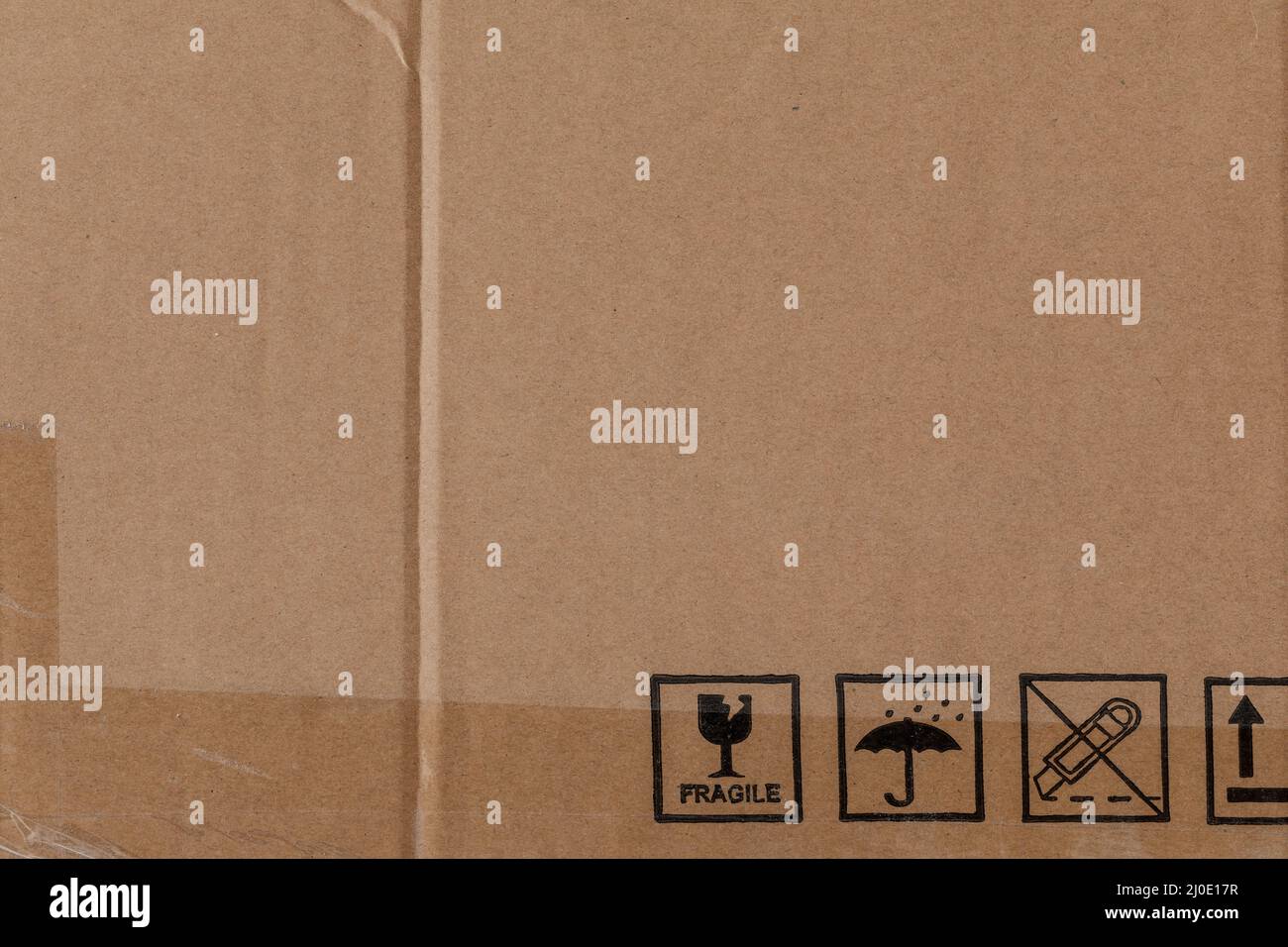 Texture de carton usée avec ruban transparent et symboles de sécurité Banque D'Images