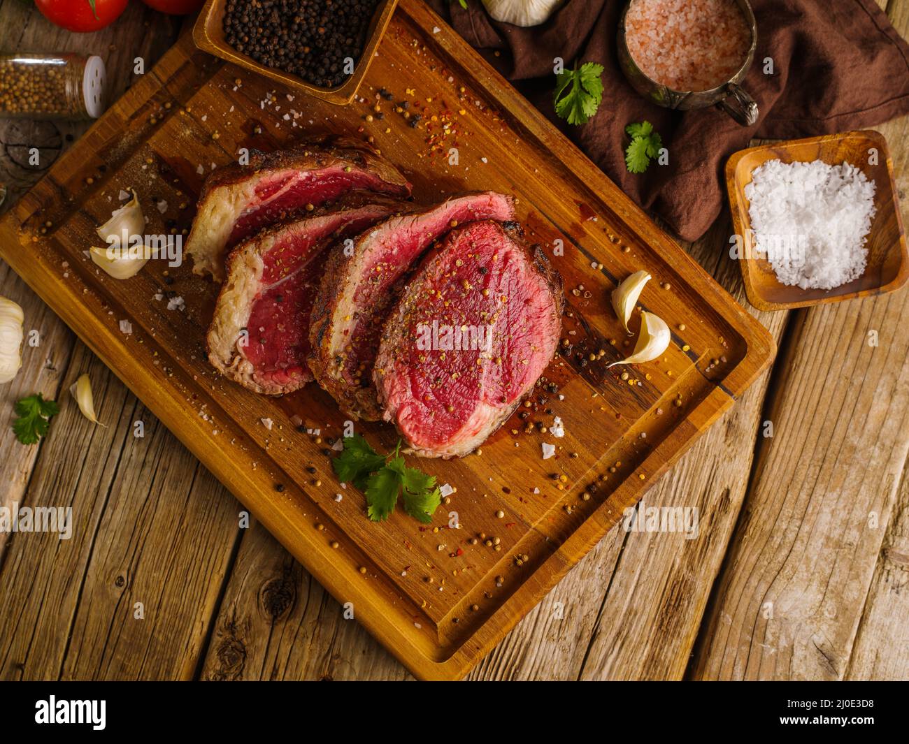 Morceaux crus de viande, porc, veau, bœuf parsemés d'épices sur fond de bois. Vue à angle bas. Cuisson de steaks de viande. Restaurant, hôtel, cuisine maison Banque D'Images