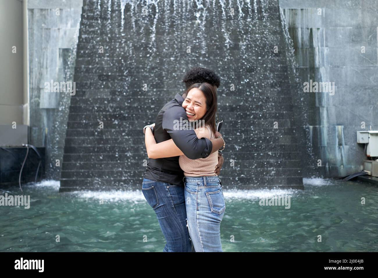 Des amis de différentes origines ethniques se sont enhués devant un centre commercial Banque D'Images