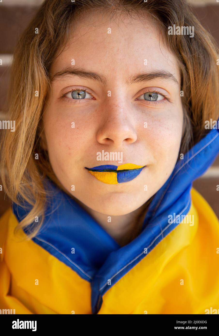 visage d'une jeune femme aux lèvres peintes jaune-bleu. Espoir et foi, fierté de la nation ukrainienne. Soutenir l'Ukraine Banque D'Images