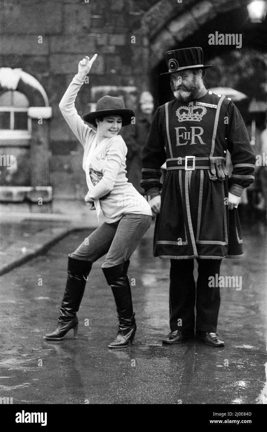 Beefeater Rory Crozier regarde avec incrédulité la danseuse disco Lucia Catti (18) passe à l'épreuve lors d'une visite à la Tour de Londres. 8th décembre 1978. Banque D'Images