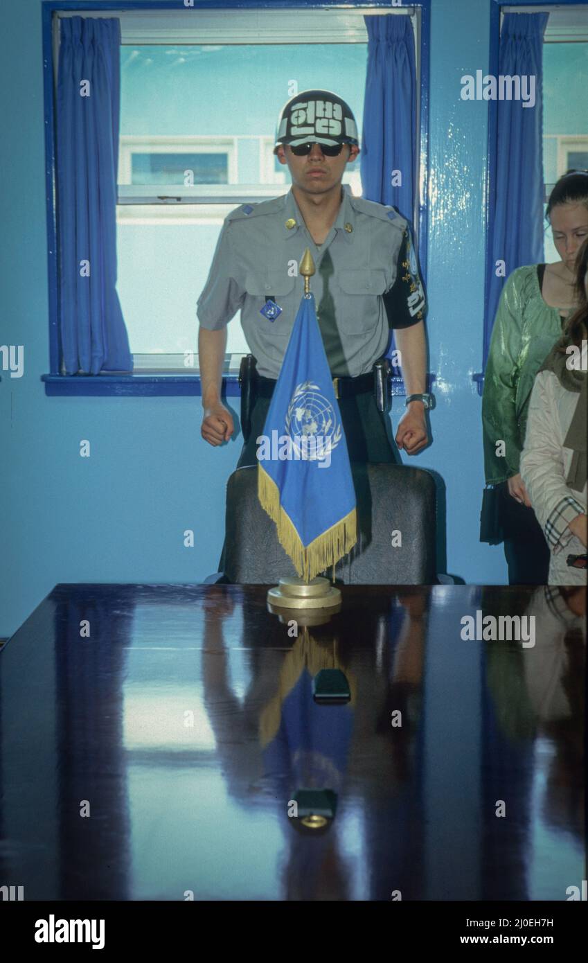 Un soldat sud-coréen est toujours sous garde lorsque les touristes visitent le bâtiment historique de la conférence des négociations de cessez-le-feu sur la ligne de démarcation d'aujourd'hui à Panmunjeom. Banque D'Images