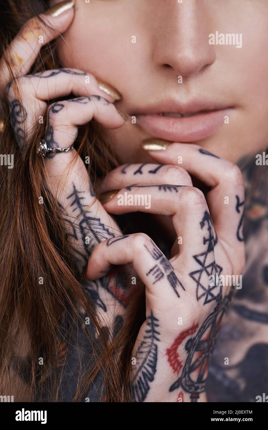 Beauté enkorporée. Une petite photo d'une jeune femme tatouée. Banque D'Images