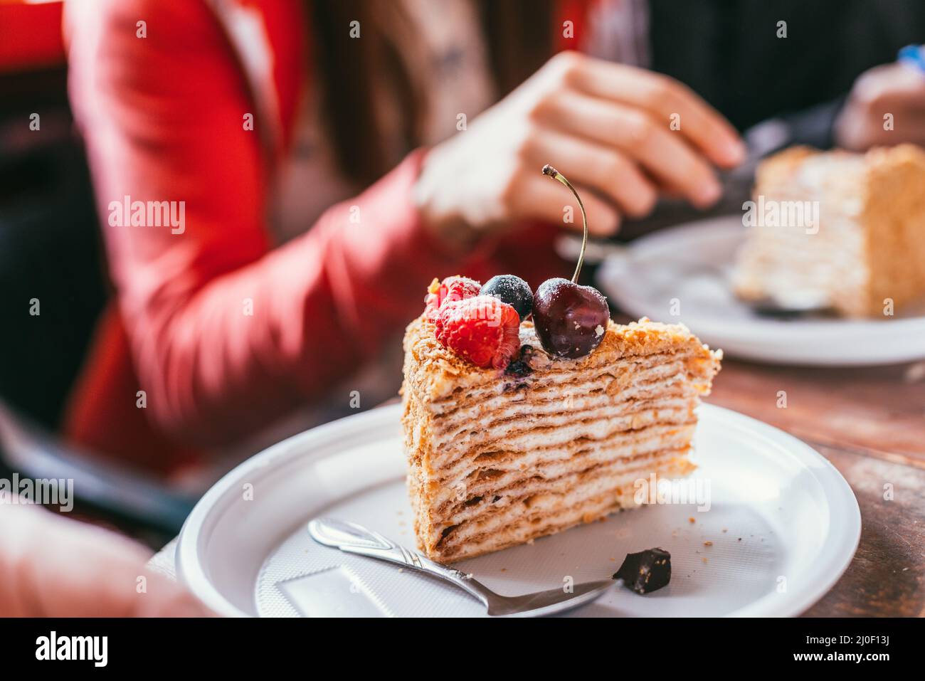 Gâteau d'anniversaire de mûres de mûre dans une assiette blanche sur le fond d'une main femelle. Prise de vue macro avec mise au point sélective avec Banque D'Images