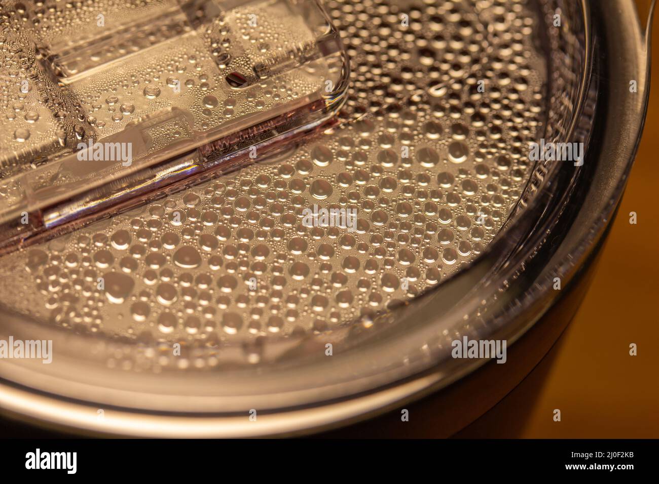 Macro résumé texture vue des gouttelettes de vapeur se condenser sur le couvercle transparent d'une tasse à café chaud Banque D'Images