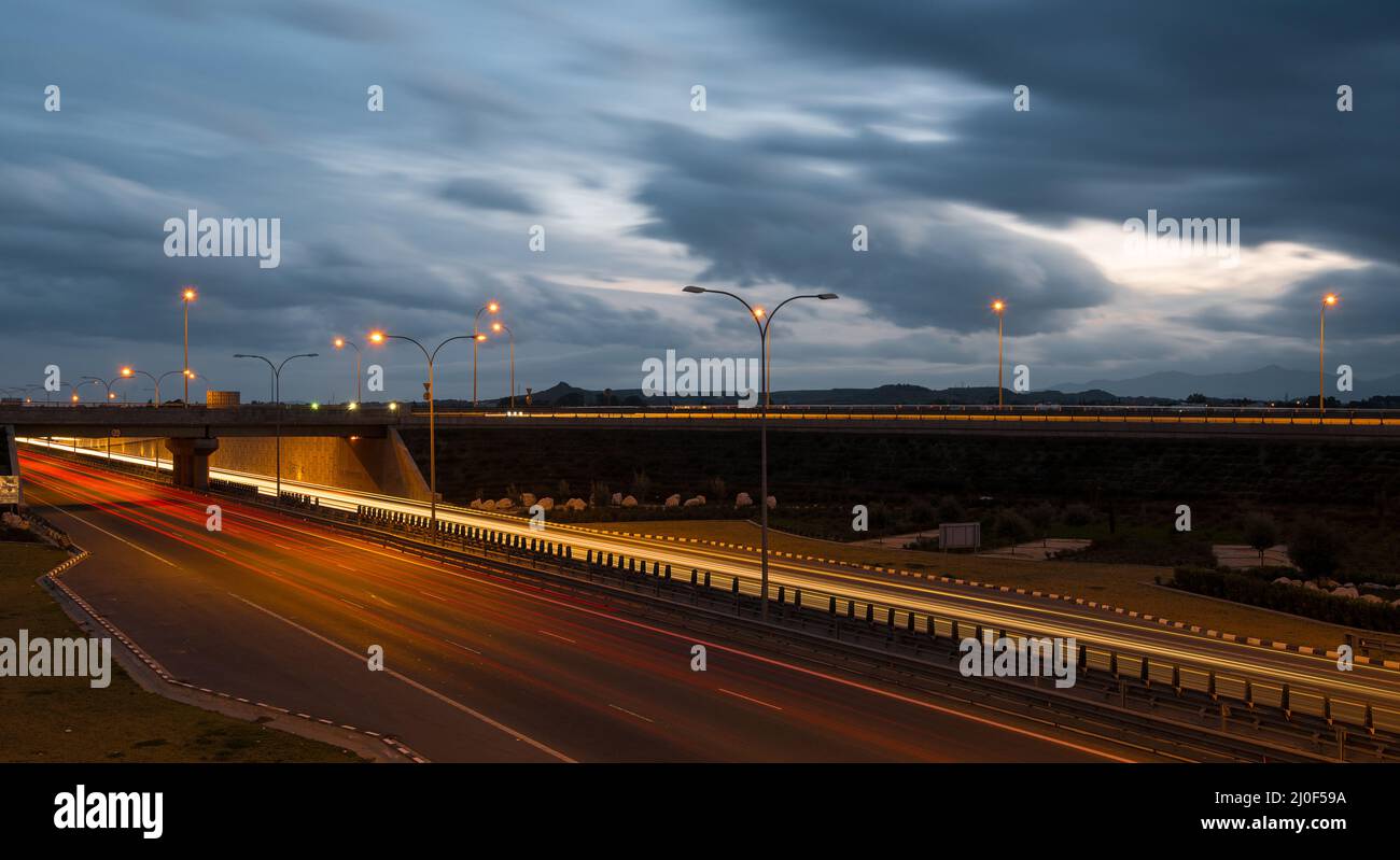 Des sentiers légers de voitures rapides sur une autoroute Banque D'Images