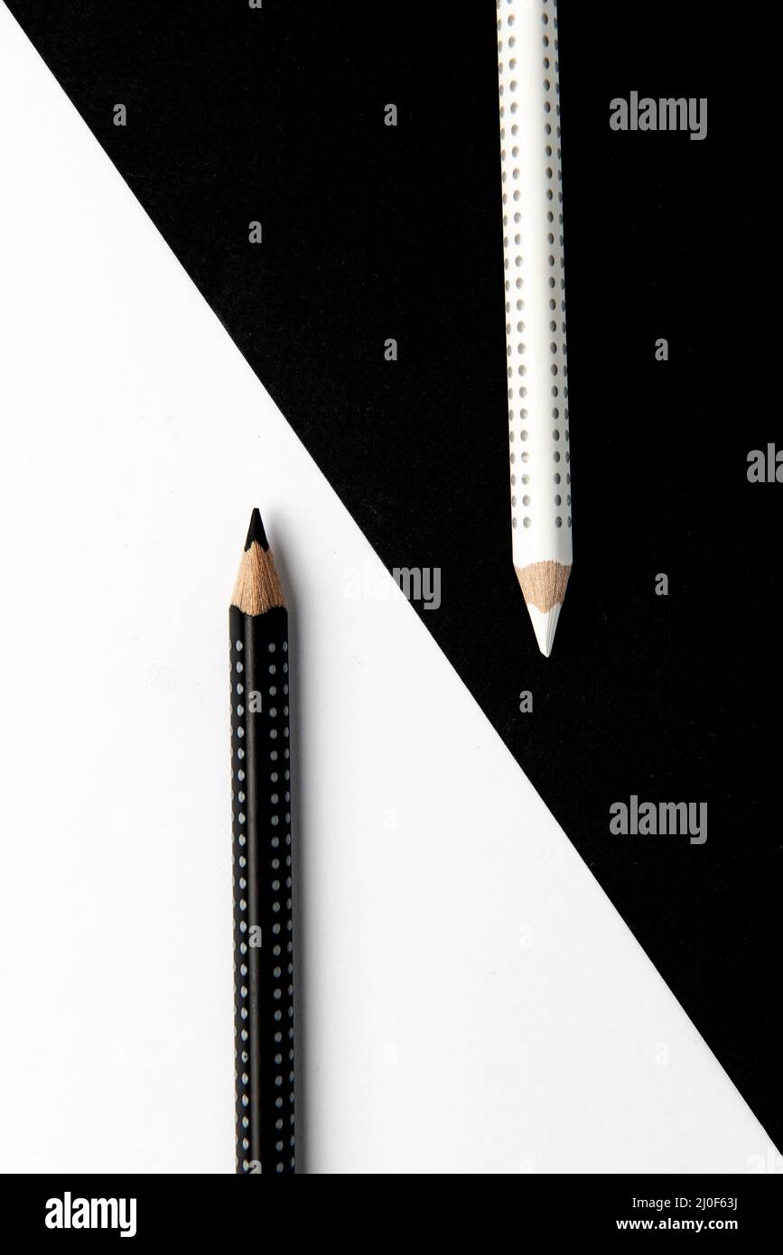 Deux crayons à dessin sur une surface noire et blanche. Banque D'Images