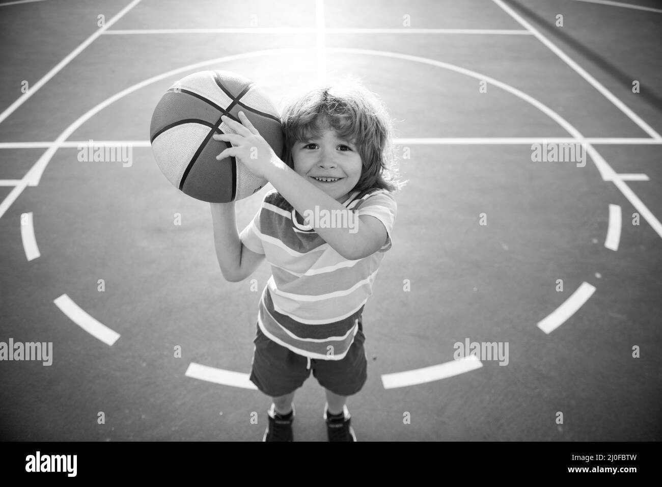 Enfant petit garçon jouant au basket-ball avec basket-ball. Banque D'Images