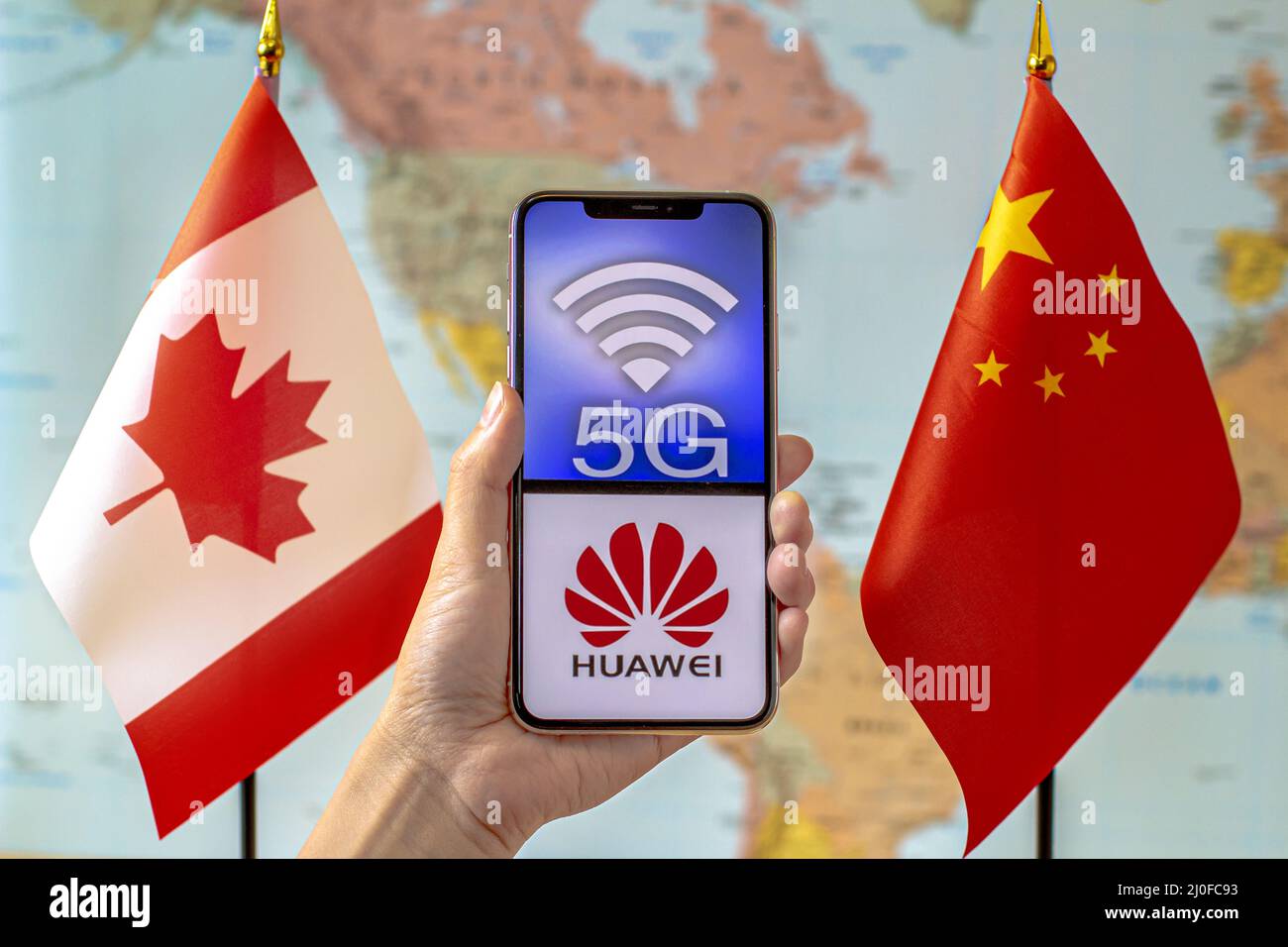 Calgary, Alberta, Canada. 8 septembre 2020. Une personne portant un iPhone avec un logo 5G et Huawei sur l'écran à côté d'un Canada et d'un C Banque D'Images