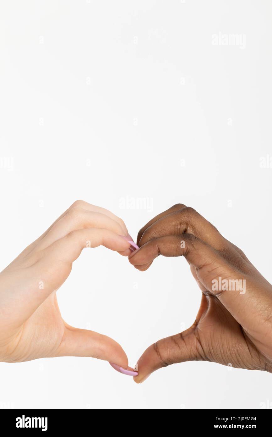 La forme d'un coeur composé de deux mains de races différentes, africaine et européenne. Ce coeur de l'amour est un message pour tous Banque D'Images
