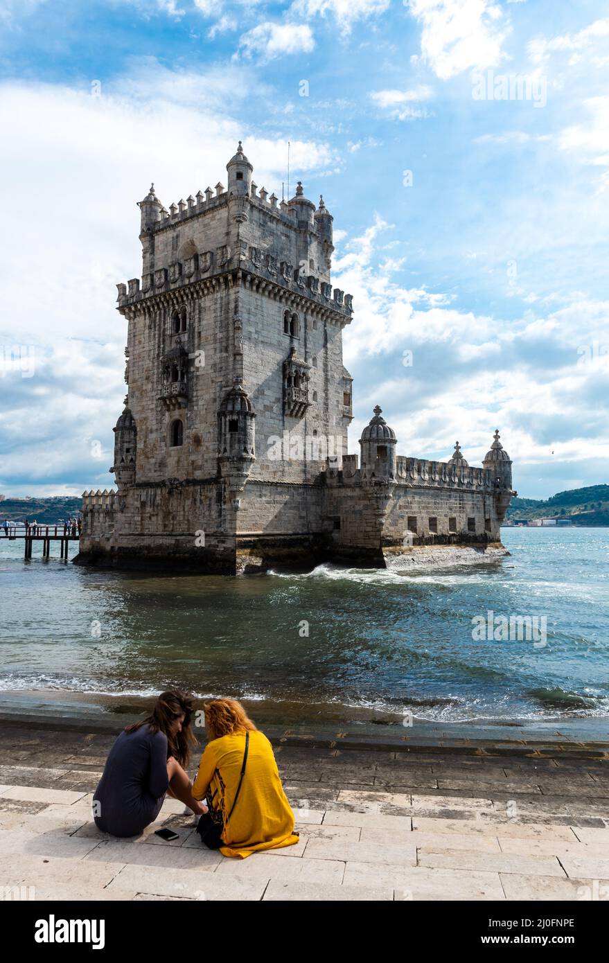 Les jeunes filles de touristes se trouvent en face de la tour Belem au Tage, à Lisbonne, au Portugal Banque D'Images