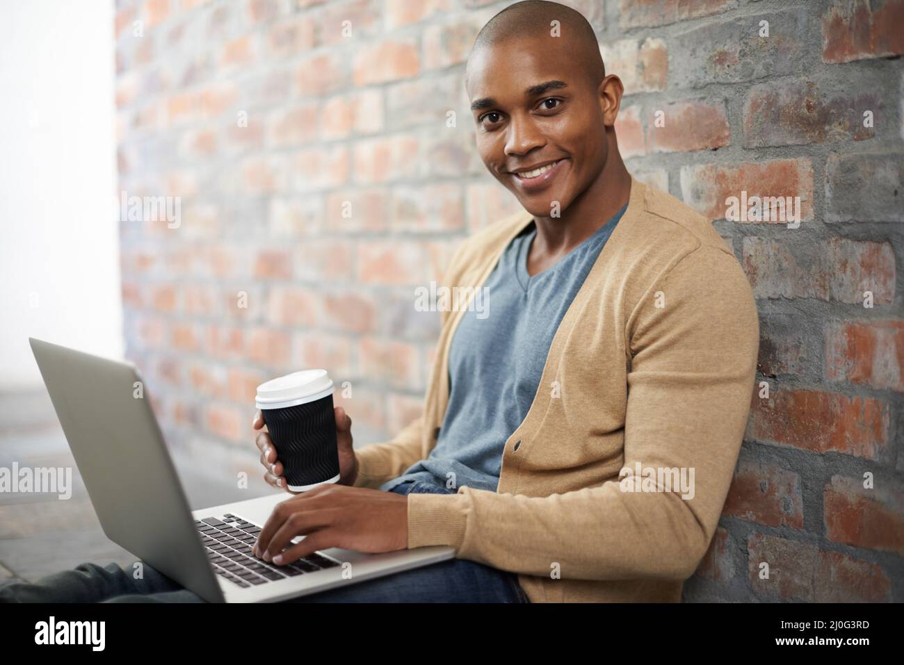 Il est facile à travailler lorsque vous vous sentez à l'aise. Photo courte d'un beau jeune homme travaillant sur un ordinateur portable. Banque D'Images