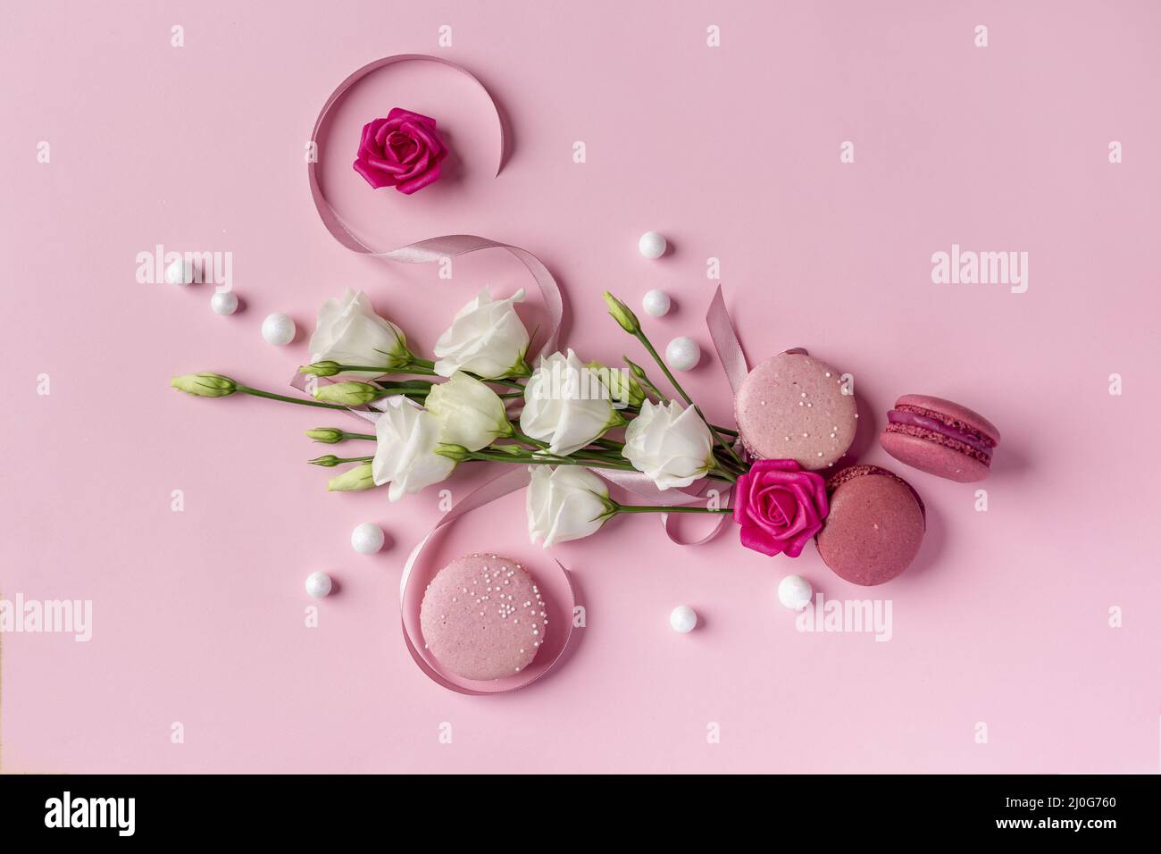 Concept international de la journée des femmes créé à partir de roses blanches et roses, ruban et perles sur un fond blanc rose clair Banque D'Images
