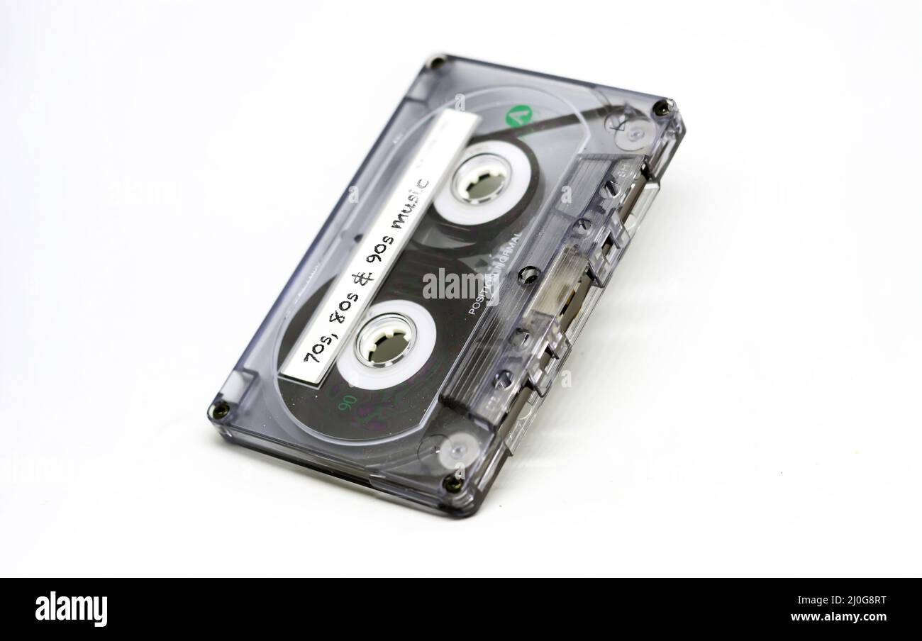Cassette audio transparente avec musique des 70s, 80s et 90s inscrite sur l'étiquette adhésive. Une technologie obsolète Banque D'Images