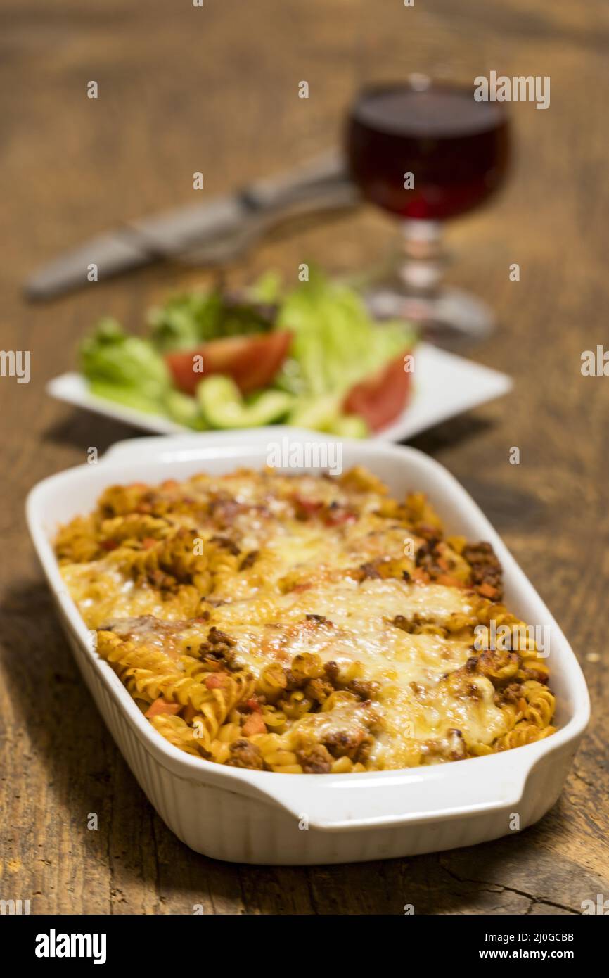 Pâtes au gratin avec salade sur bois Banque D'Images