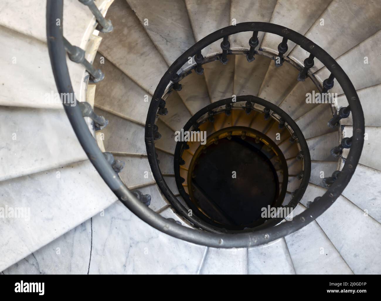 Ancien escalier en colimaçon avec marches en marbre et main courante en