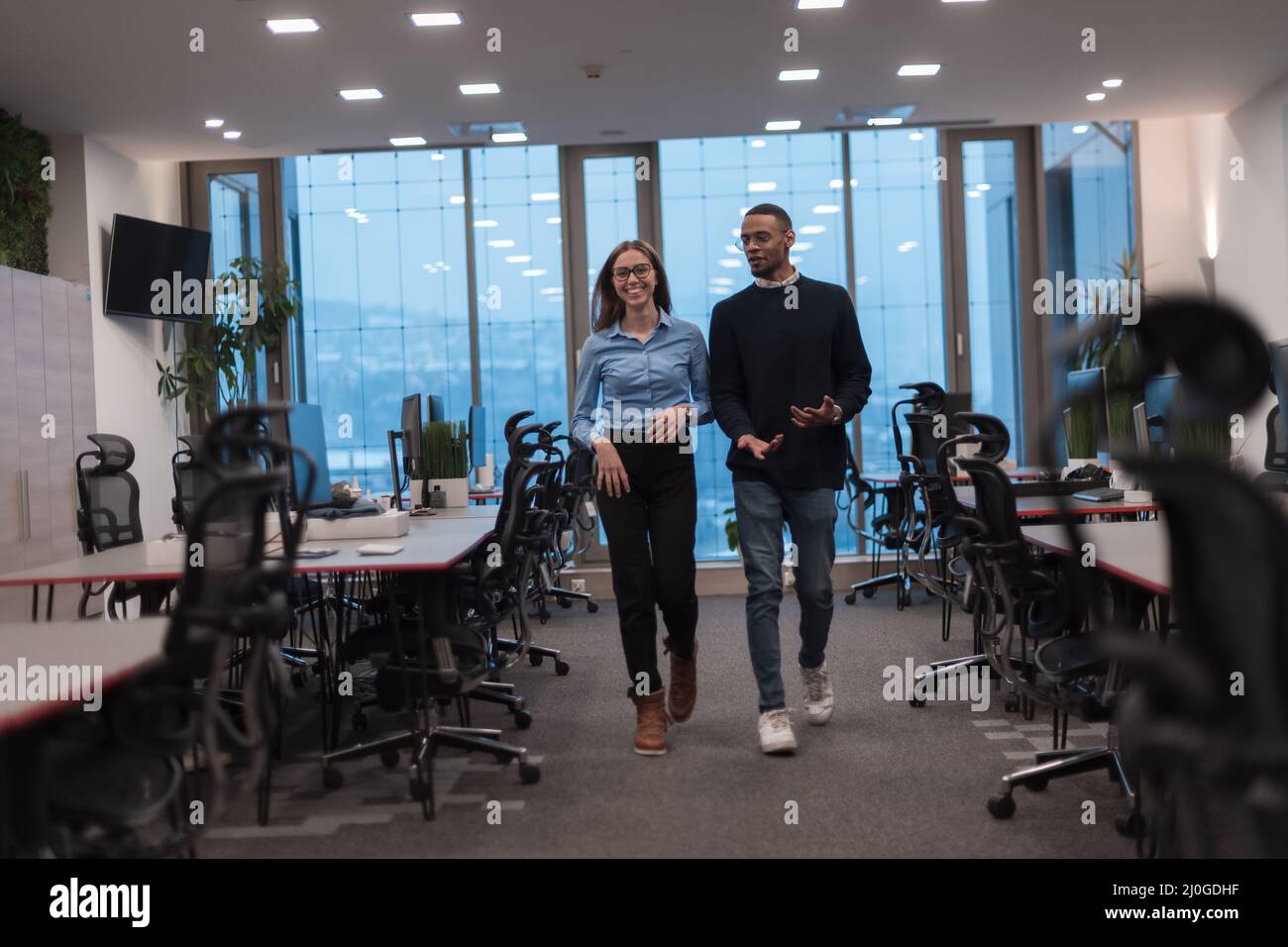 Deux heureux divers professionnels de l'équipe de direction d'affaires personnes femme et homme afro-américain marchant dans le bureau de collègue. Entreprise multiculturelle Banque D'Images
