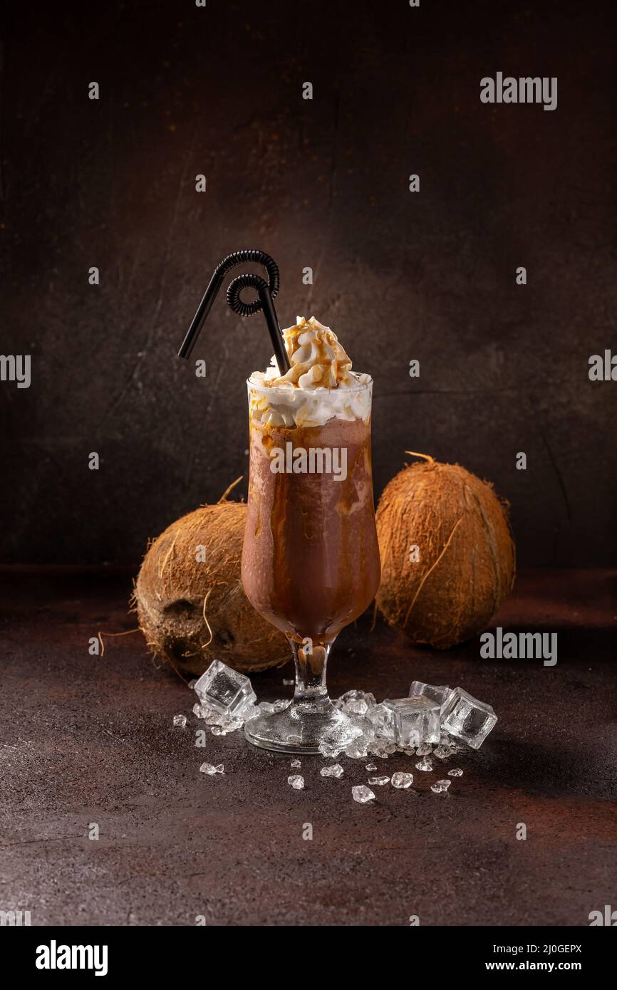 Délicieux café froid rafraîchissant dans un verre à cocktail à la noix de coco Banque D'Images