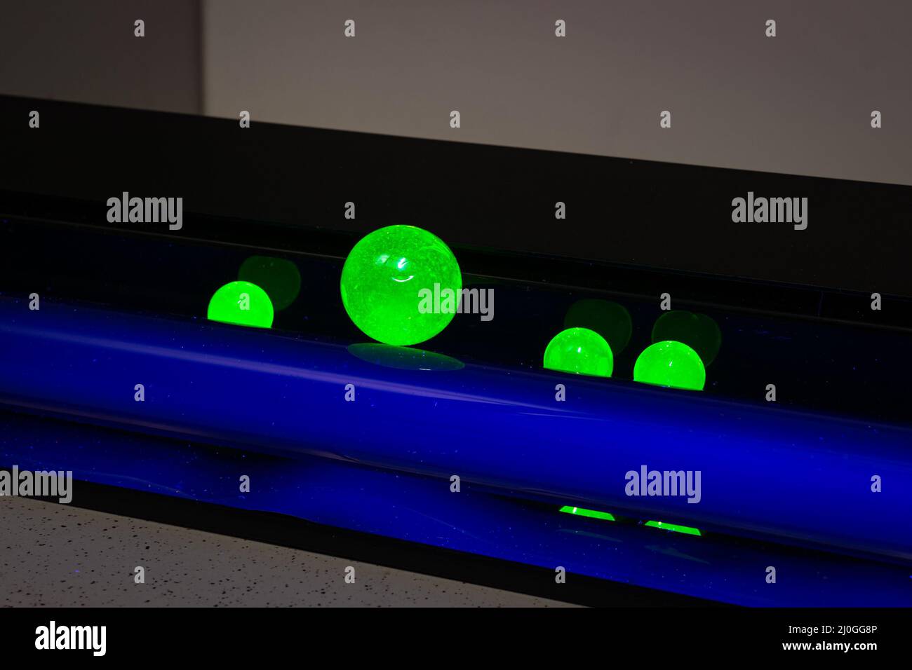Les billes spéciales d'un laboratoire sont illuminées par une lampe ultraviolette, également appelée « lumière noire » et présentent une fluorescence Banque D'Images