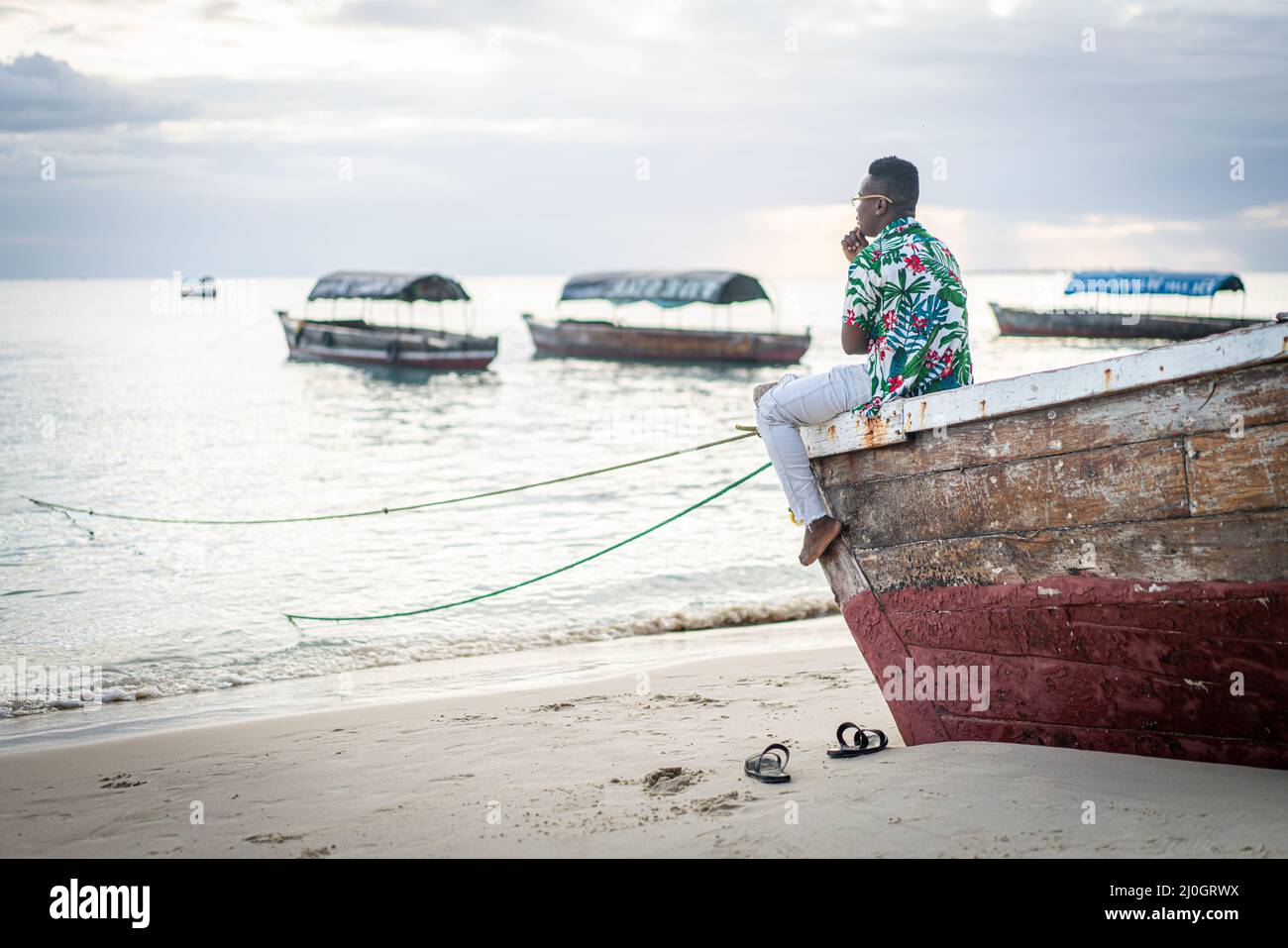 Jeune homme noir assis sur un bateau prenant le selfie Banque D'Images