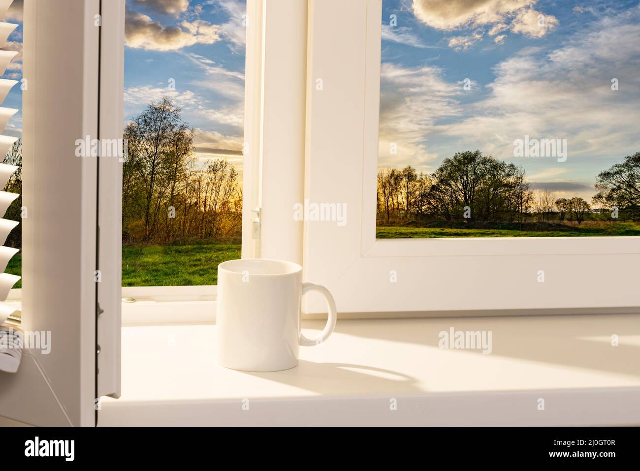 Ouvrez la fenêtre avec une tasse de café sur le rebord de la fenêtre Banque D'Images
