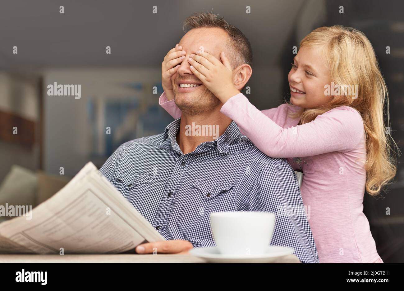 Devinez qui. Prise de vue d'une jeune fille surprend son père en couvrant ses mains sur ses yeux. Banque D'Images