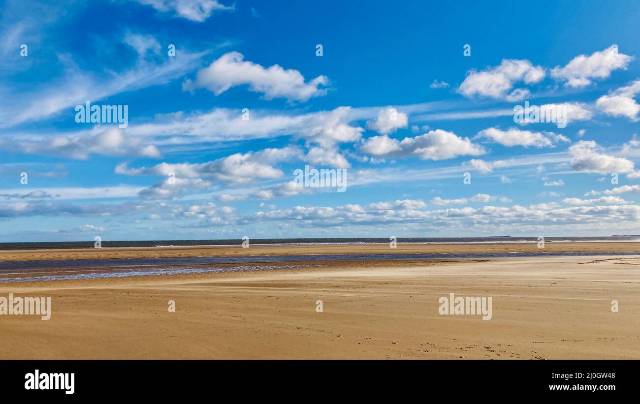 Ciel bleu avec formations de nuages sur la plage de sable d'Alnmouth Beach sur la côte de Northumberland dans le nord-est de l'Angleterre. Banque D'Images