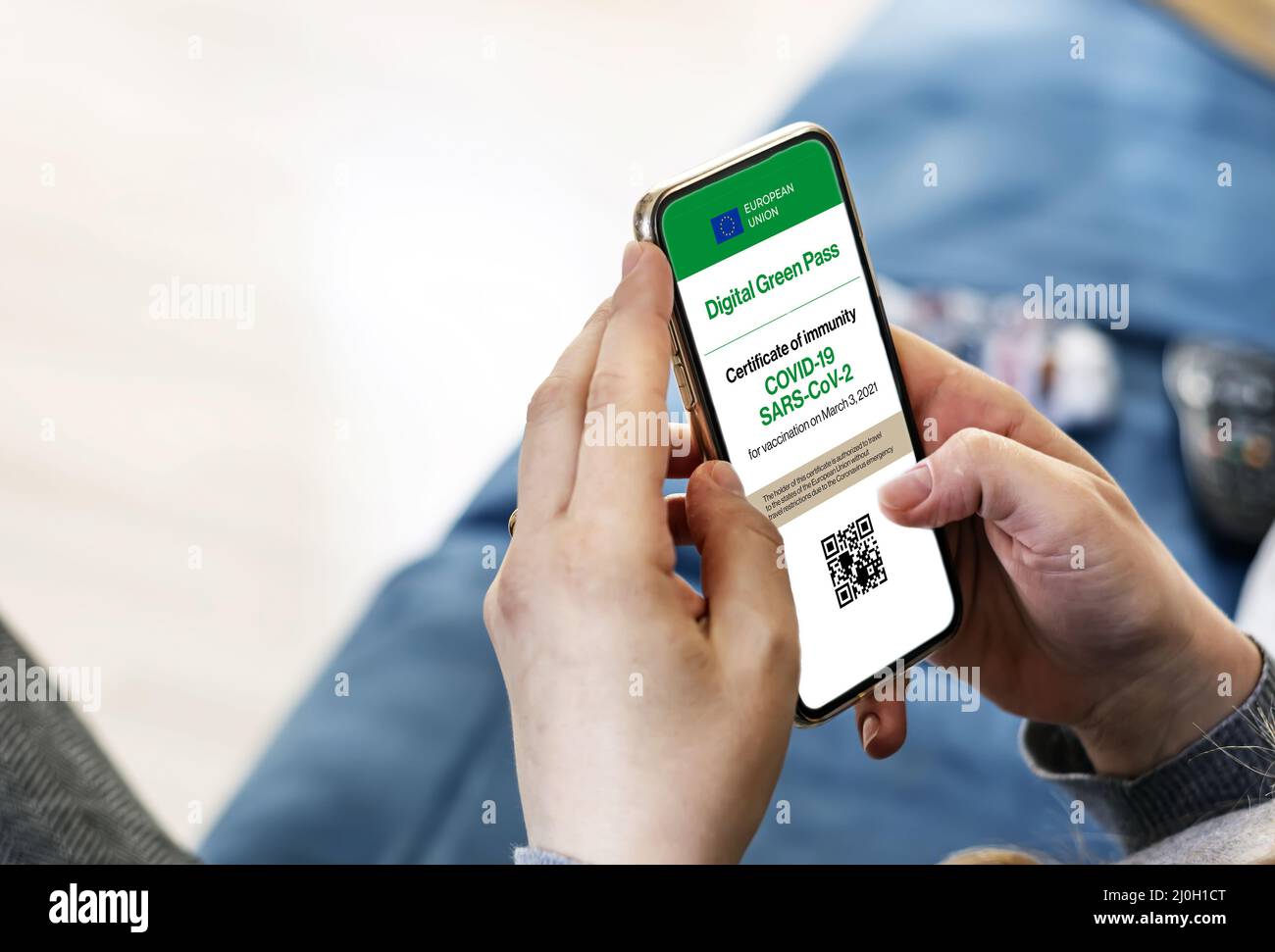 Femme tenant un smartphone avec certificat numérique Covid-19 à l'écran Banque D'Images
