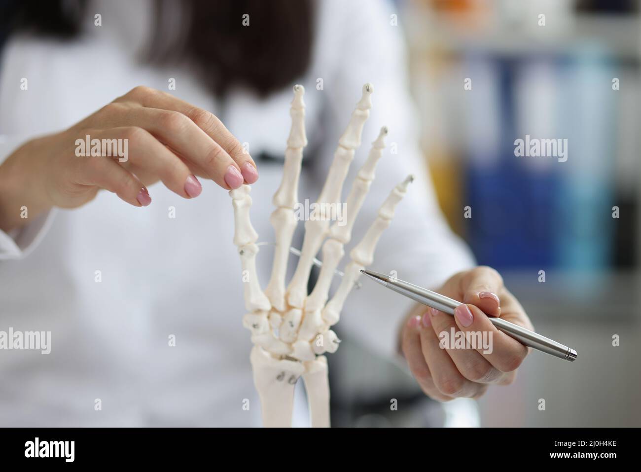 La scientifique féminine explore le modèle de main de squelette humain, les sciences de laboratoire et de l'anatomie médicale Banque D'Images