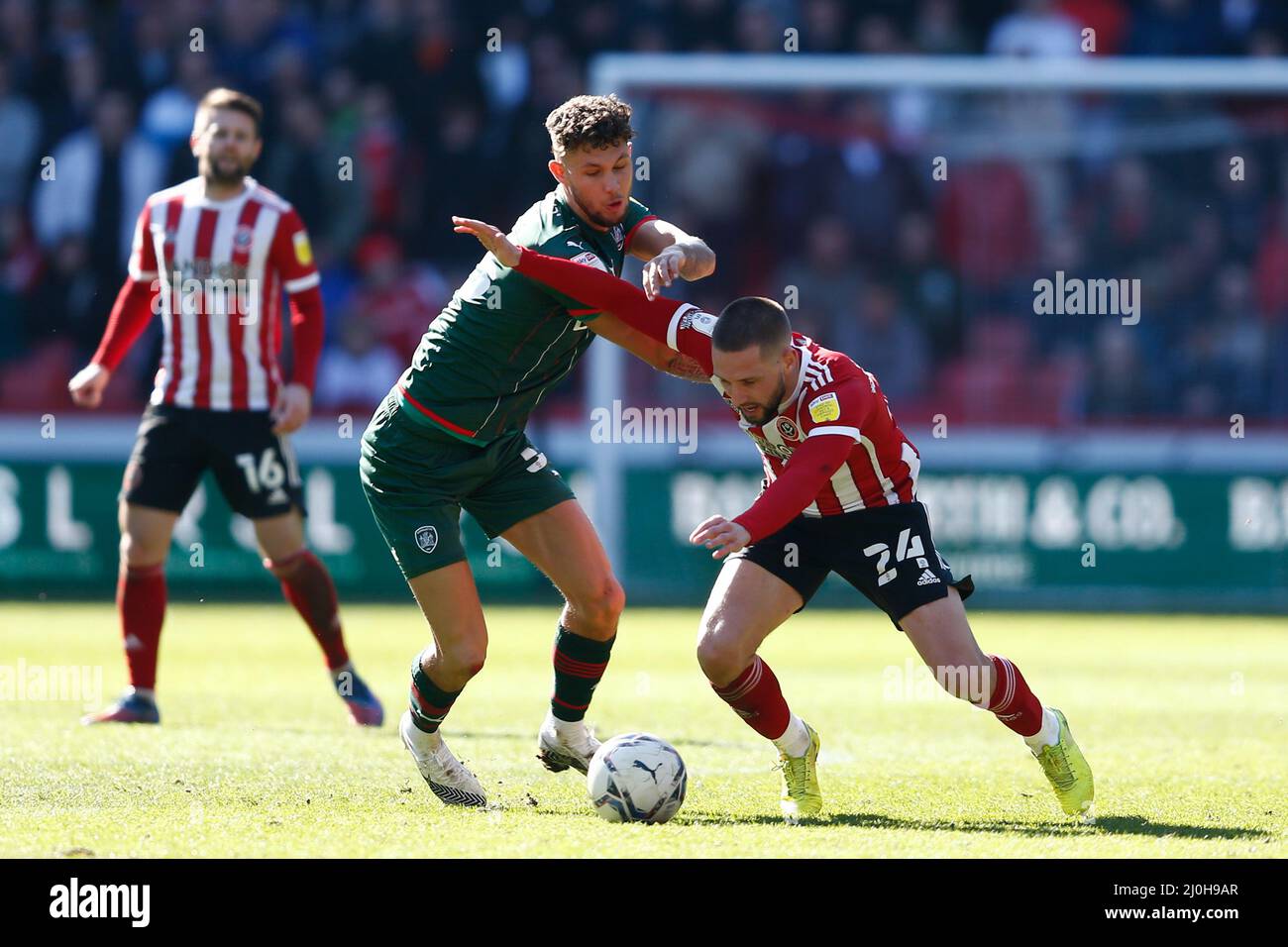 Connor Hourihane de Sheffield United et Matty Wolfe de Barnsley en action pendant le match du championnat Sky Bet à Bramall Lane, Sheffield. Date de la photo: Samedi 19 mars 2022. Banque D'Images