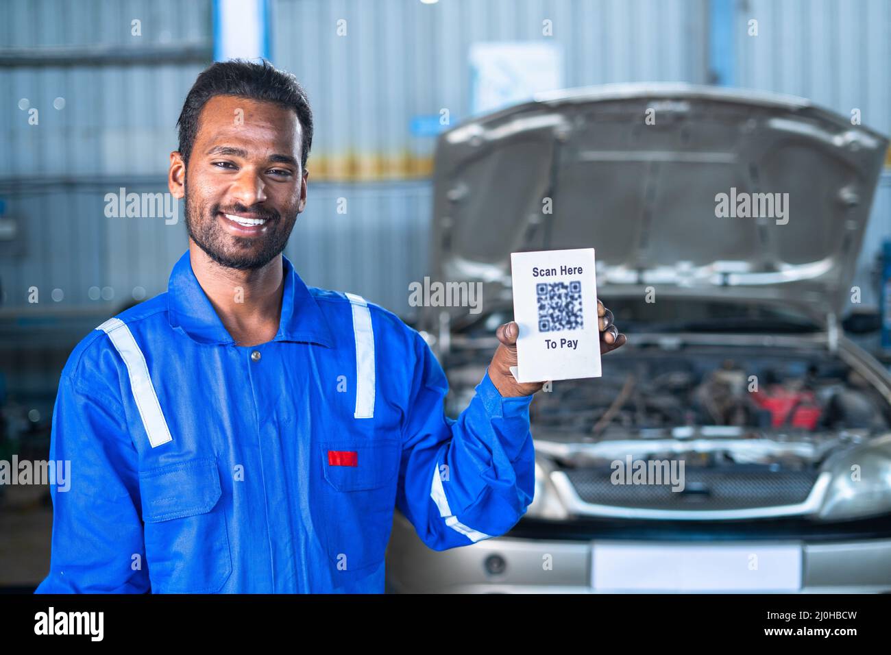 car mécanicien montrant scanner ici pour payer le tableau de code qr pour le paiement par la recherche de caméra - concept de paiement numérique, technologie et transaction sans espèces Banque D'Images