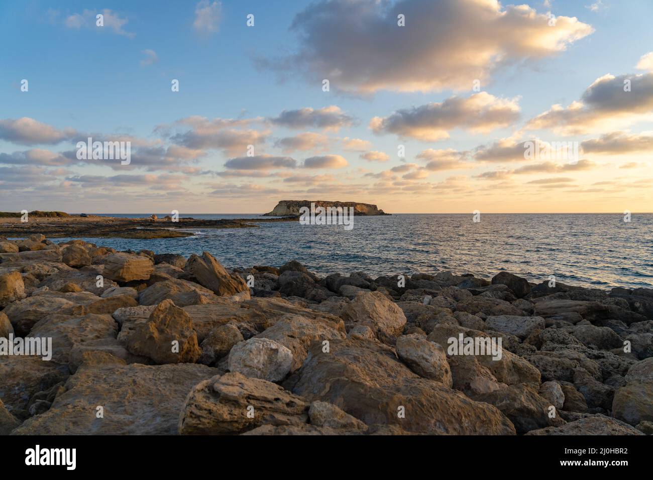 Côte rocheuse d'Agios Georgios Chypre. Vue sur l'île de Yeronisos. Coucher de soleil sur le port d'Agios Georgios Pegeias à Paphos, Chypre. T Banque D'Images