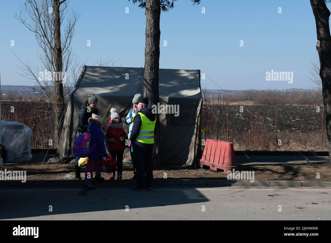 Une famille attend de monter à bord d'un bus qui les emmène à la ville de Suceava en Roumanie. Environ 3 mille personnes arrivent quotidiennement à Siret, en Roumanie, pour se réfugier contre la violence causée par la guerre entre la Russie et l'Ukraine. Dans cette ville frontalière, un couloir d'aide humanitaire a été organisé entre diverses organisations civiles et étatiques. Les personnes qui fuient l'Ukraine sont principalement des femmes, des enfants et des adultes plus âgés. Lorsqu'ils franchissent la frontière, les gens reçoivent de l'aide médicale, psychologique, alimentaire, de transport et d'hébergement. Grâce à l'aide des bénévoles, ces gens peuvent prendre une pause et gagner de la force pour continuer Banque D'Images