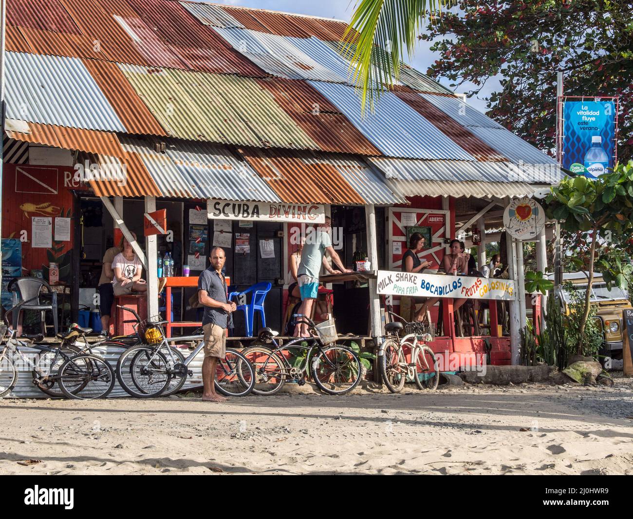 Groupe de personnes avec leurs vélos qui le prennent facilement en face d'une entreprise dans la ville des Caraïbes de Puerto Viejo, Costa Rica. Banque D'Images