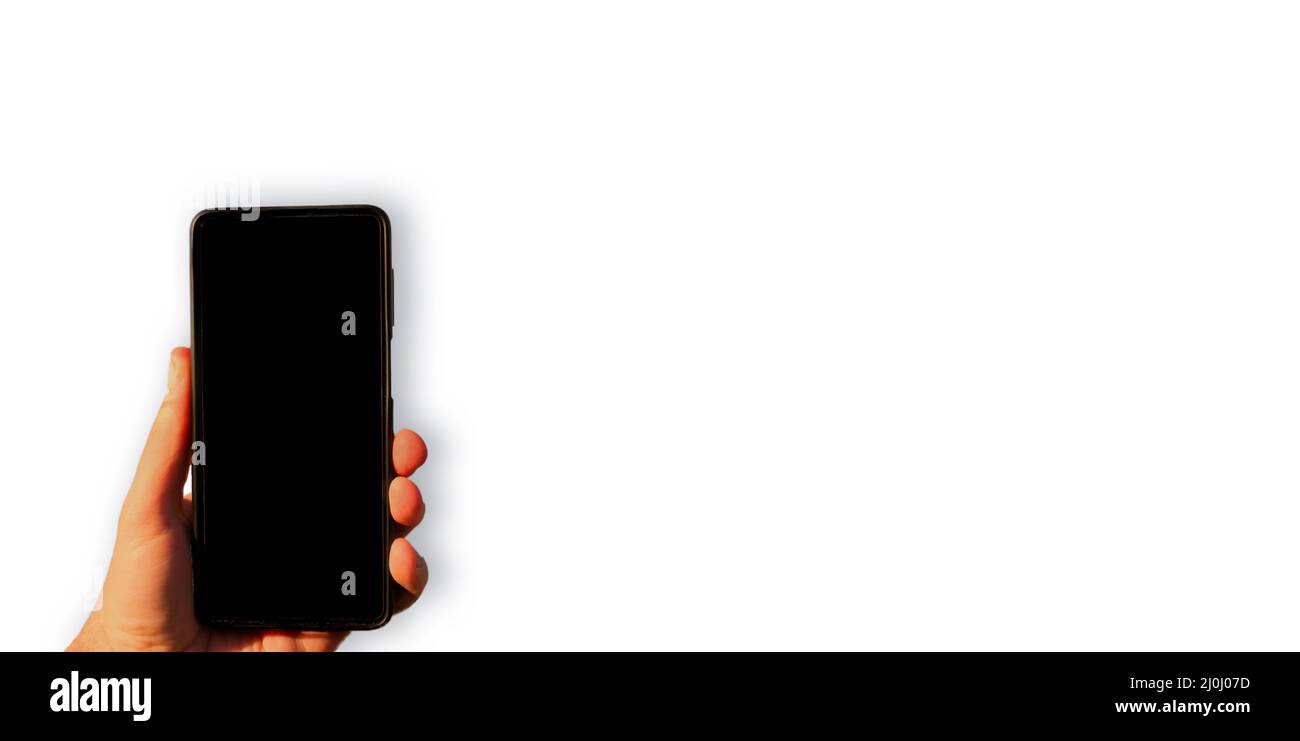 Homme tenant main smartphone avec écran noir vide gros plan isolé sur fond blanc. Grand espace de copie, espace vide pour les publicités ou les textes publicitaires. Banque D'Images