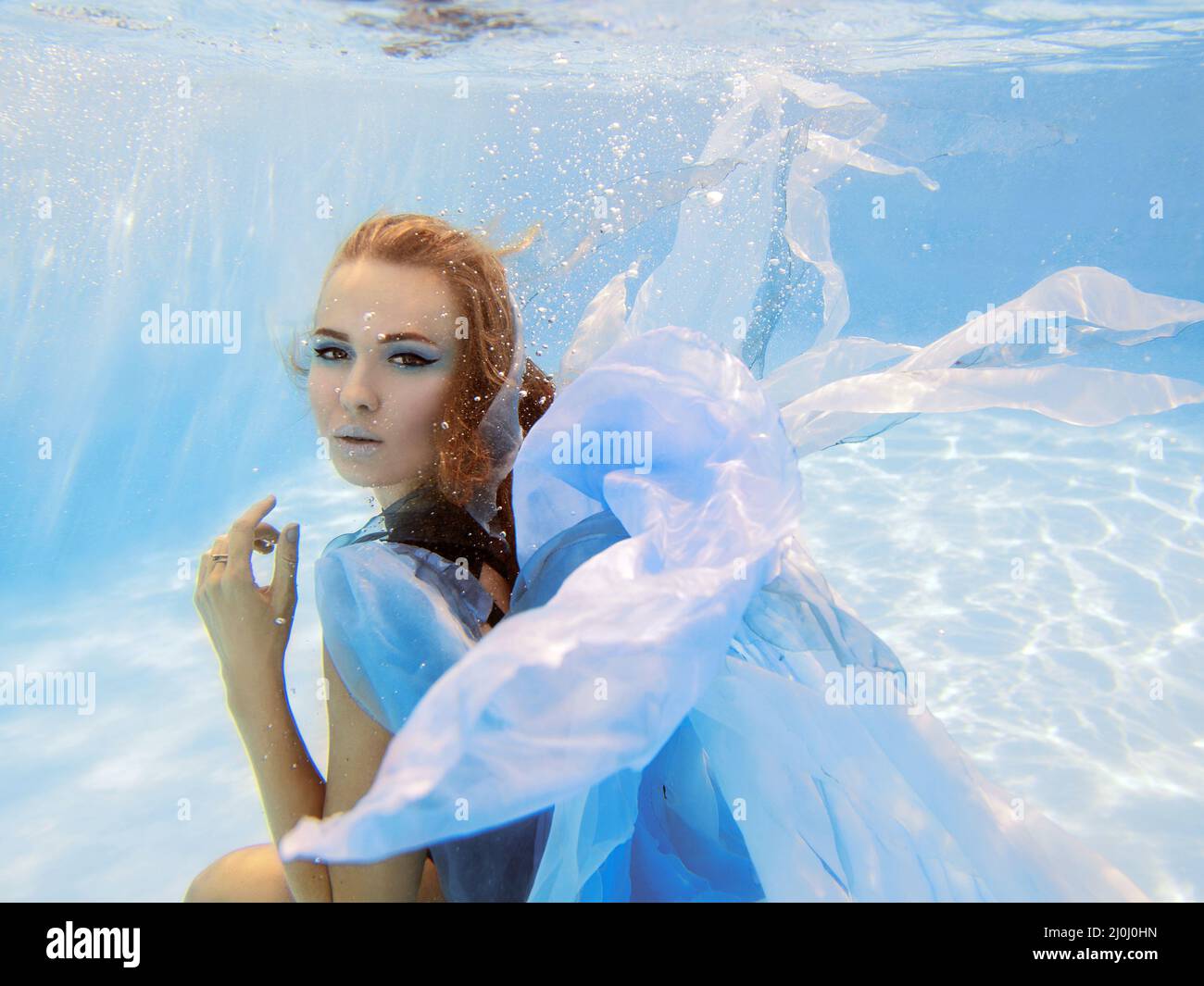 Portrait de mode sous-marin de la belle jeune femme en robe bleue Banque D'Images