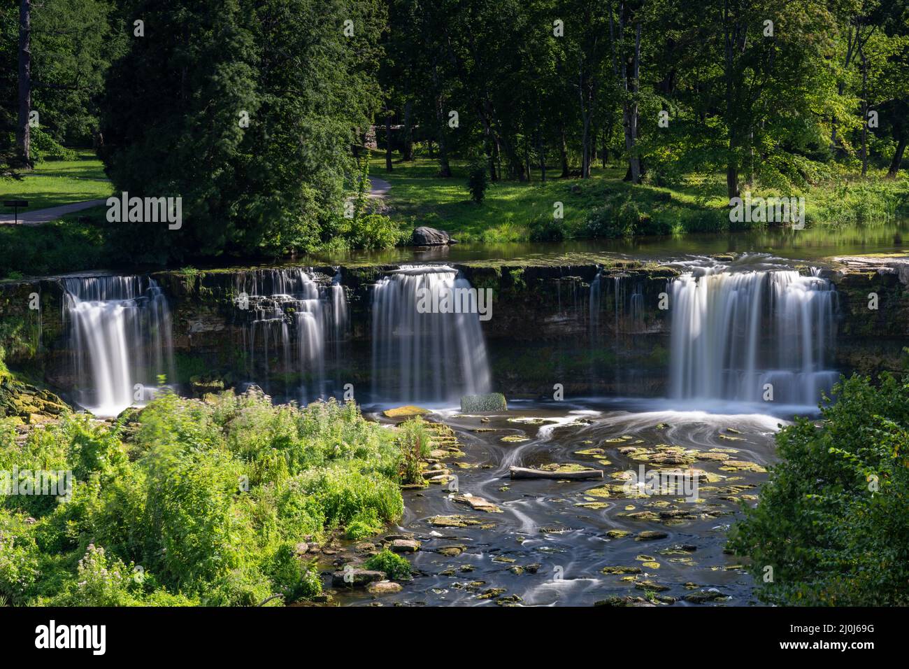 Paysage de rivière idyllique dans la forêt avec une cascade Banque D'Images