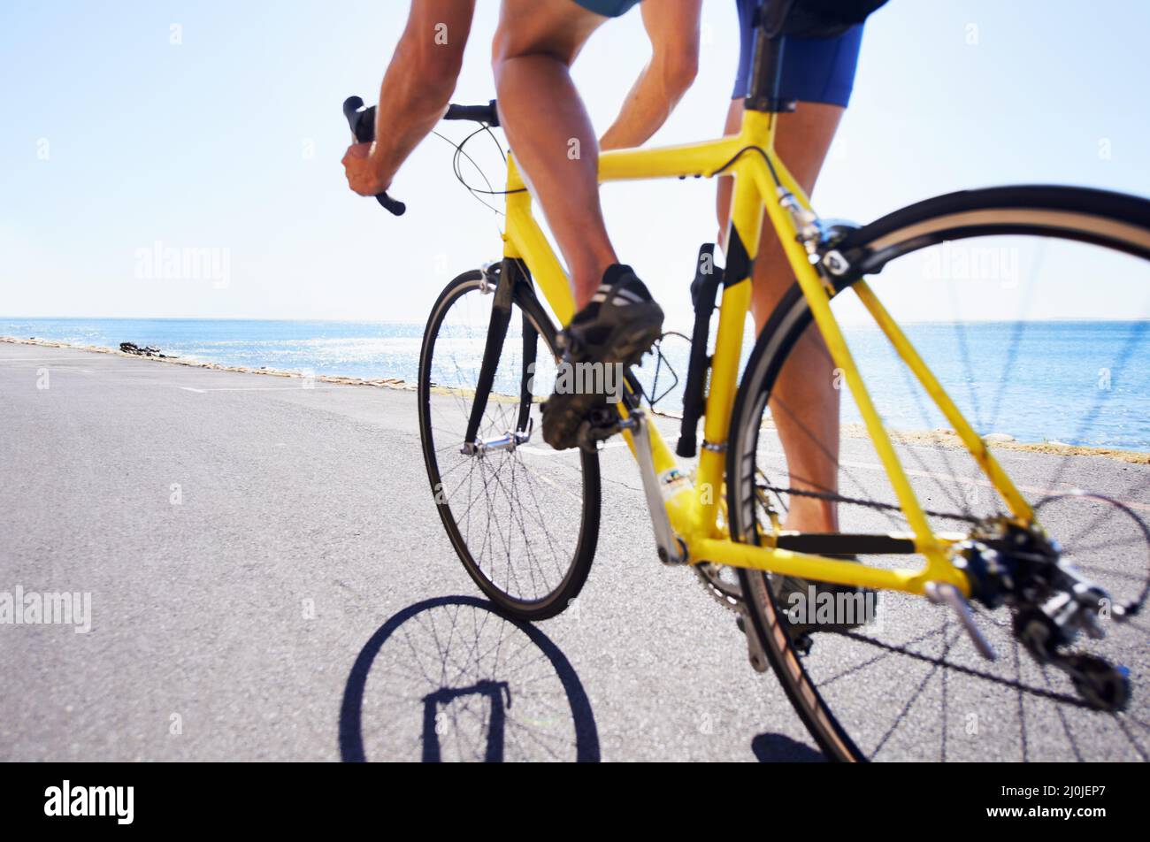 Profitez du paysage tout en faisant de l'exercice. Vue rognée d'un cycliste le long d'une route océanique. Banque D'Images