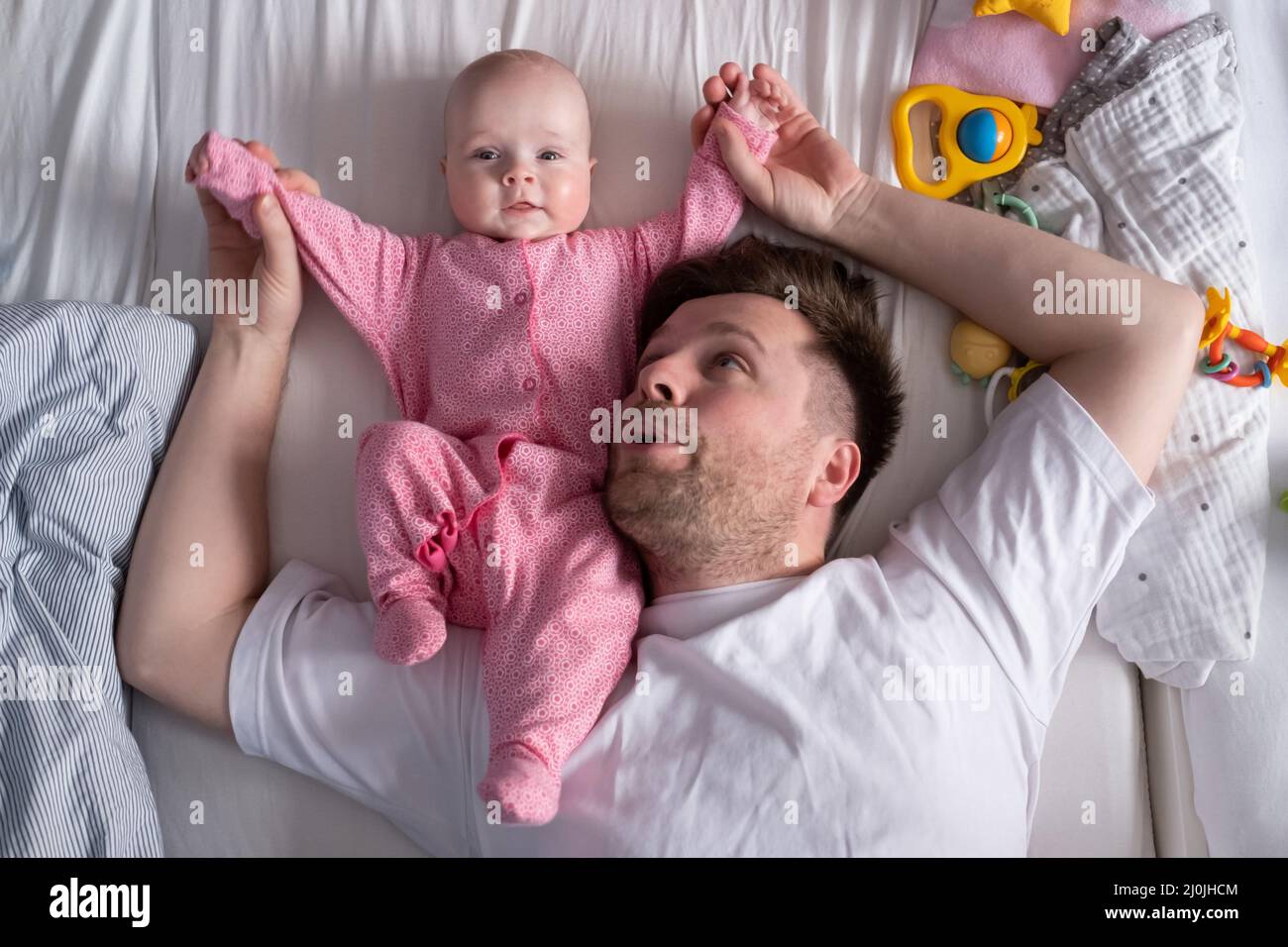 Le père caucasien et l'enfant mignon se reposant ensemble dans le lit.Concept de paternité Banque D'Images