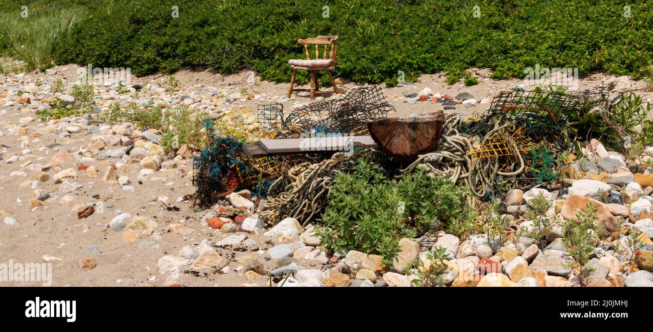 Vieux casiers à homard et corde dans une pile de déchets sur une plage entourée de rochers à Narragansett Rhode Island. Banque D'Images